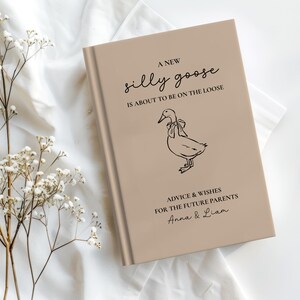 Op de afbeelding: Een beige boek met de tekst "A New Silly Goose is About to Be on the Loose." Een lijntekening van een gans met een strik staat onder de tekst. Het boek bevat ook "Advice & Wishes for the Future Parents" en namen.