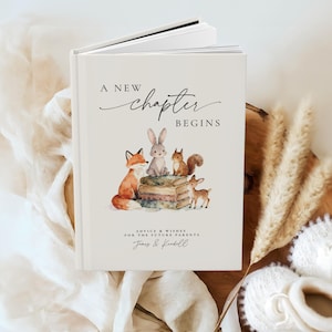 May include: A hardcover book with the text "A New Chapter Begins" and a watercolor illustration of woodland animals. The cover features a fox, rabbit, squirrel, and deer. Below the title is the text "Advice & Wishes for the Future Parents".