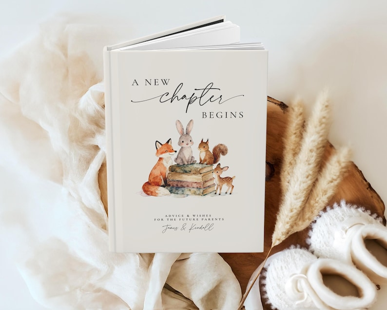 May include: A hardcover book with the text "A New Chapter Begins" and a watercolor illustration of woodland animals. The cover features a fox, rabbit, squirrel, and deer. Below the title is the text "Advice & Wishes for the Future Parents".