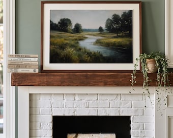 Op de afbeelding: Een landschapsschilderij in een donkere houten lijst met een kronkelende rivier door een grasrijk weiland met bomen onder een zachte lucht. Het kunstwerk staat boven een schoorsteenmantel met een stapel boeken en een groene plant.