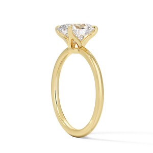 May include: A gold solitaire engagement ring with a large, round, clear diamond.