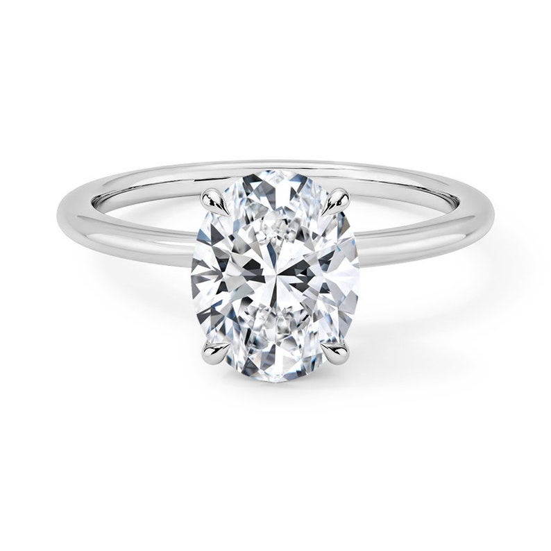 May include: A silver solitaire engagement ring with a large oval-shaped diamond.