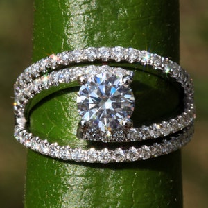 May include: A silver ring with a large, round, clear diamond set in a twisted band. The band is adorned with smaller diamonds.
