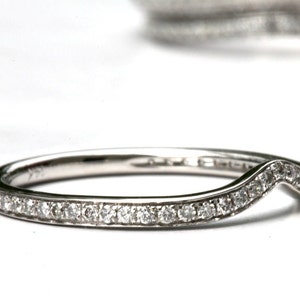 Puede incluir: Una fina banda de plata con un dise&ntilde;o curvo en forma de V. La banda est&aacute; engastada con peque&ntilde;os diamantes redondos.