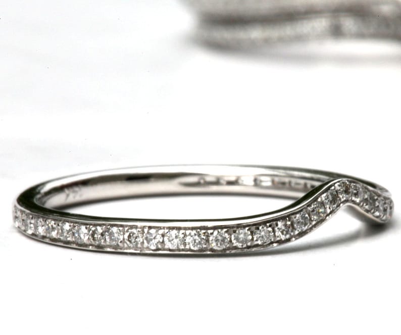 Puede incluir: Una fina banda de plata con un dise&ntilde;o curvo en forma de V. La banda est&aacute; engastada con peque&ntilde;os diamantes redondos.
