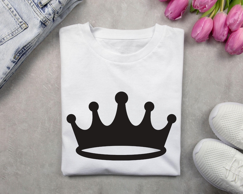 May include: White t-shirt with a black crown graphic.