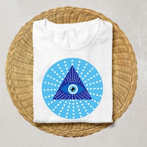 May include: White t-shirt with a blue and white evil eye design. The eye is inside a triangle with rays of light emanating from it.