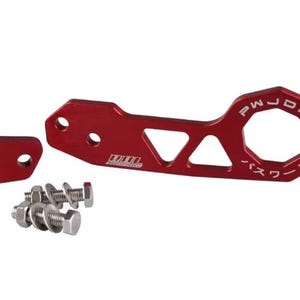 May include: A red car tow hook with the text "PWJDM" and Japanese characters. The hook has an octagonal ring and a triangular cutout. Includes a small red plate and several bolts and washers.