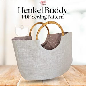 Może przedstawiać: Jasnoszara torba z uchwytami z bambusa. Torba ma zaokrąglony kształt i wzorzyste wnętrze. Tekst "Henkel Buddy PDF Sewing Pattern" jest wyświetlany u góry obrazu.