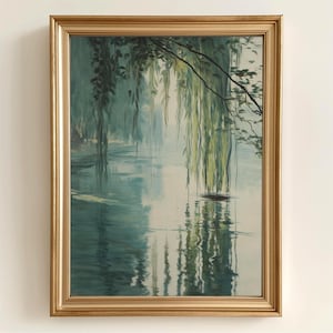 Puede incluir: Una pintura enmarcada que representa una escena tranquila de un lago con sauces llorones que cuelgan sobre el agua. El agua es de color azul verdoso claro y refleja los árboles y el cielo. La pintura está en un marco dorado.