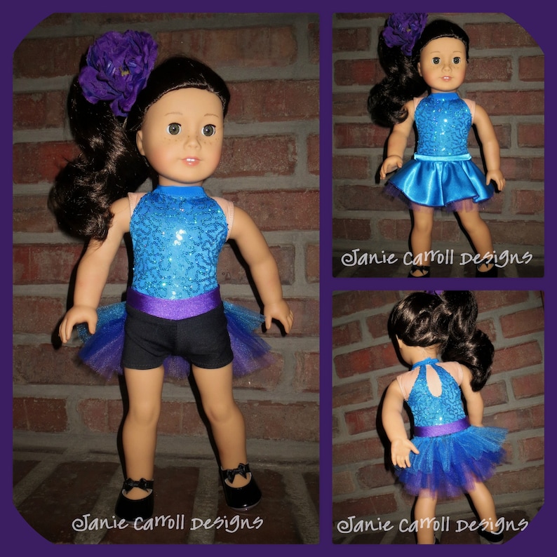 May include: A blue and purple sequined leotard with a black skirt and a tulle overlay. The doll is wearing black shoes and a purple flower in her hair. The image is captioned "Janie Carroll Designs".