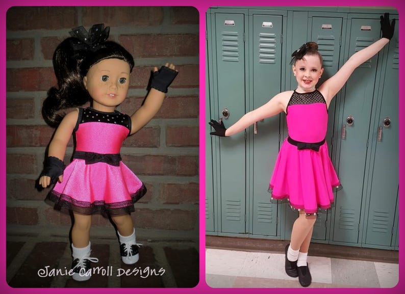 May include: Two girls wearing pink and black dance dresses with black gloves and black shoes. The girl on the left is a doll. The girl on the right is a human. The background is a brick wall and a row of green lockers.