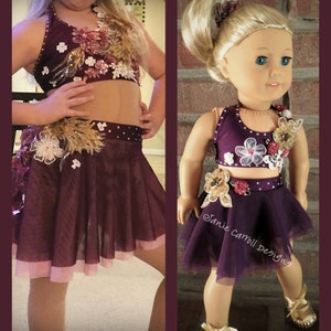 May include: A two-piece dance costume for a young girl. The top is a burgundy halter top with floral embellishments and rhinestones. The skirt is a burgundy tulle skirt with a pink lining and floral embellishments.