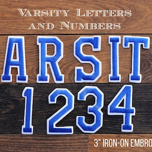 May include: Embroidered varsity letters and numbers in blue with white trim, displayed on a wooden background. The word "VARSITY" is spelled out, along with the numbers "1234". Each patch is 3 inches.