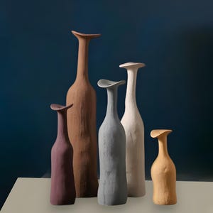 May include: Five ceramic vases in different colors and shapes. The vases are arranged in a row on a white surface. The vases are all made of a textured material and have a unique design.