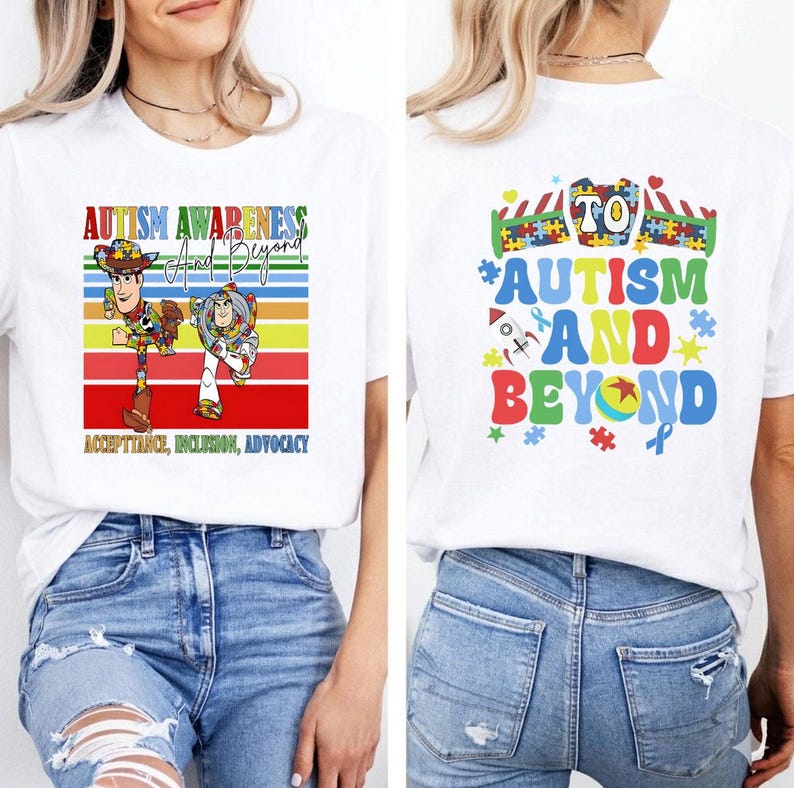 K&ouml;nnte beinhalten: Wei&szlig;es T-Shirt mit einer farbenfrohen Grafik zur F&ouml;rderung des Autismus-Bewusstseins. Auf der Vorderseite sind Woody und Buzz Lightyear mit dem Text "Autism Awareness and Beyond" und "Acceptance, Inclusion, Advocacy" abgebildet. Auf der R&uuml;ckseite steht "Autism and Beyond" mit Puzzleteilen und einem Band.