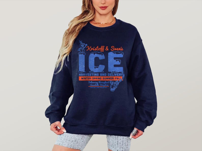 May include: A navy blue sweatshirt with the text "Kristoff & Sven's ICE" in orange and blue. The sweatshirt features a graphic of a cartoon character and the words "Harvesting and Delivery" and "Winter-Spring-Summer-Fall".