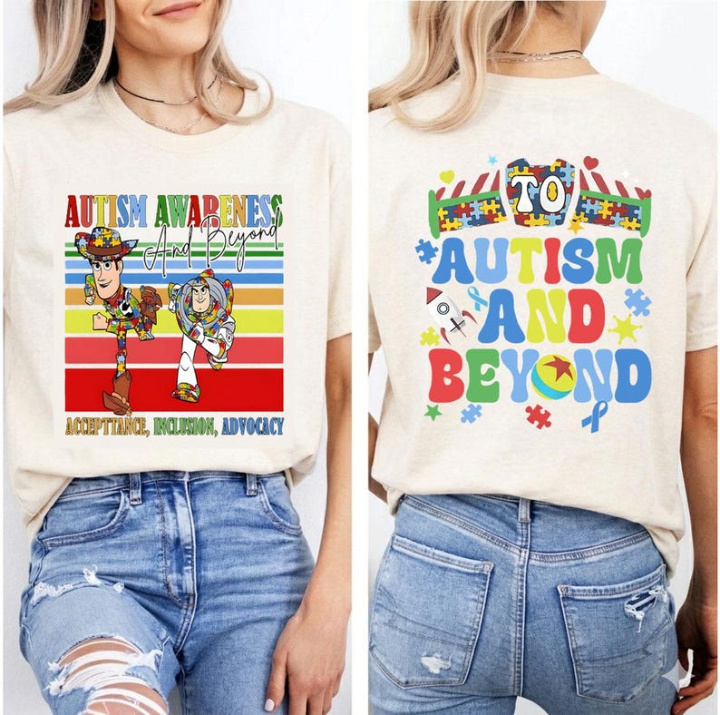K&ouml;nnte beinhalten: Beiges T-Shirt mit dem Text "Autism Awareness And Beyond" und einer Grafik von Woody und Buzz Lightyear. Das Shirt enth&auml;lt auch die Worte "Acceptance, Inclusion, Advocacy". Auf der R&uuml;ckseite des Shirts steht "To Autism And Beyond" mit bunten Puzzleteilen und Sternen.