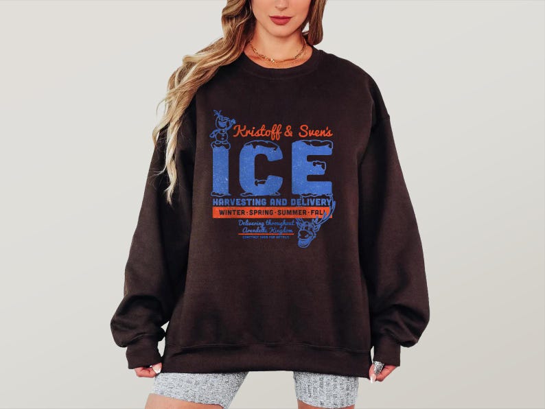 May include: A dark brown sweatshirt with the text "Kristoff & Sven's ICE" in orange and blue. The sweatshirt also features the text "HARVESTING AND DELIVERY" and "WINTER-SPRING-SUMMER-FALL".