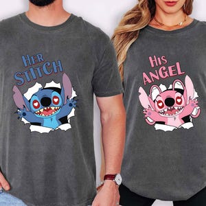 May include: Two charcoal grey t-shirts with matching graphics. One shirt says "Her Stitch" with a blue cartoon character. The other says "His Angel" with a pink cartoon character. Both characters are breaking through a white background.