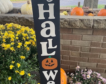 Może przedstawiać: Czarny drewniany znak z białymi literami, na którym napisano "Happy Halloween" z twarzą dyni w środku.