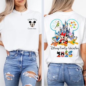 Op de afbeelding: Wit T-shirt met Mickey Mouse en de tekst "Disney 2026 Custom Name" op de voorkant. De achterkant van het shirt toont Disney-personages, een kasteel en de woorden "Disney Family Vacation 2026".