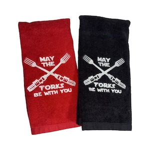 May include: Two kitchen towels, one red and one black, with the text "May the Forks Be With You" and a crossed fork design.
