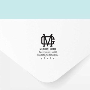 Op de afbeelding: Een witte envelop met een zwart retouradreslabel. Het label heeft een monogram met de initialen "MC" en de tekst "Meredith Collie, 1234 Hanover Street, Charlotte, North Carolina 28282."