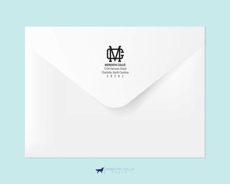 Op de afbeelding: Een witte envelop met een zwart retouradreslabel. Het label heeft een monogram met de initialen "MC" en de tekst "Meredith Collie, 1234 Hanover Street, Charlotte, North Carolina 28282."