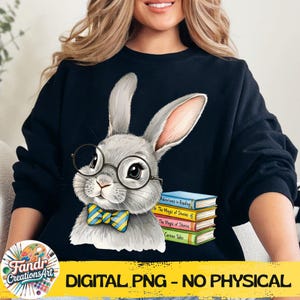 Può includere: Felpa nera con un coniglio grigio con occhiali e papillon, con una pila di libri. Il testo "DIGITAL PNG - NO PHYSICAL" è visualizzato su uno striscione giallo. L'illustrazione del coniglio ha un tema stravagante e libresco.