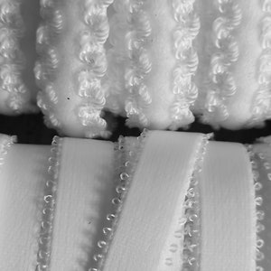 May include: Two white elastic bands with a scalloped edge. The band on top has a more textured surface. The band on the bottom has a smooth surface. The number "14" is printed above the top band and the number "15" is printed below the bottom band.