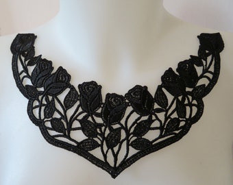 May include: Black lace collar featuring a floral rose design. The collar is shaped to sit around the neck and shoulders. The roses and leaves are intricately detailed, creating a delicate and elegant aesthetic.