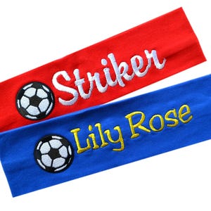 May include: Two fabric headbands with embroidered soccer balls and names. One headband is red with white embroidery and the name "Striker". The other headband is blue with yellow embroidery and the name "Lily Rose".