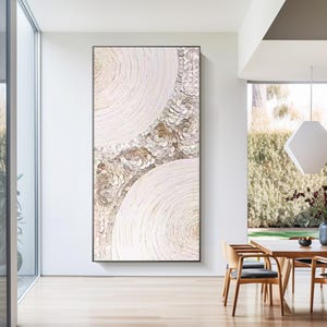 May include: Abstract art print featuring a white background with a circular design in shades of beige and brown. The design is composed of small, overlapping circles that create a textured effect.
