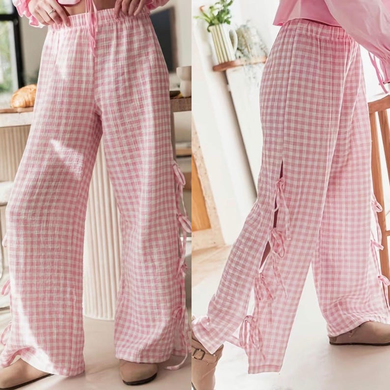 K&ouml;nnte beinhalten: Weite Hose mit rosa-wei&szlig;em Vichy-Karo-Muster. Die Hose hat einen Kordelzug in der Taille und Seitenschlitze mit rosa Schleifen. Der Stoff scheint eine leichte Baumwoll- oder Leinenmischung zu sein.