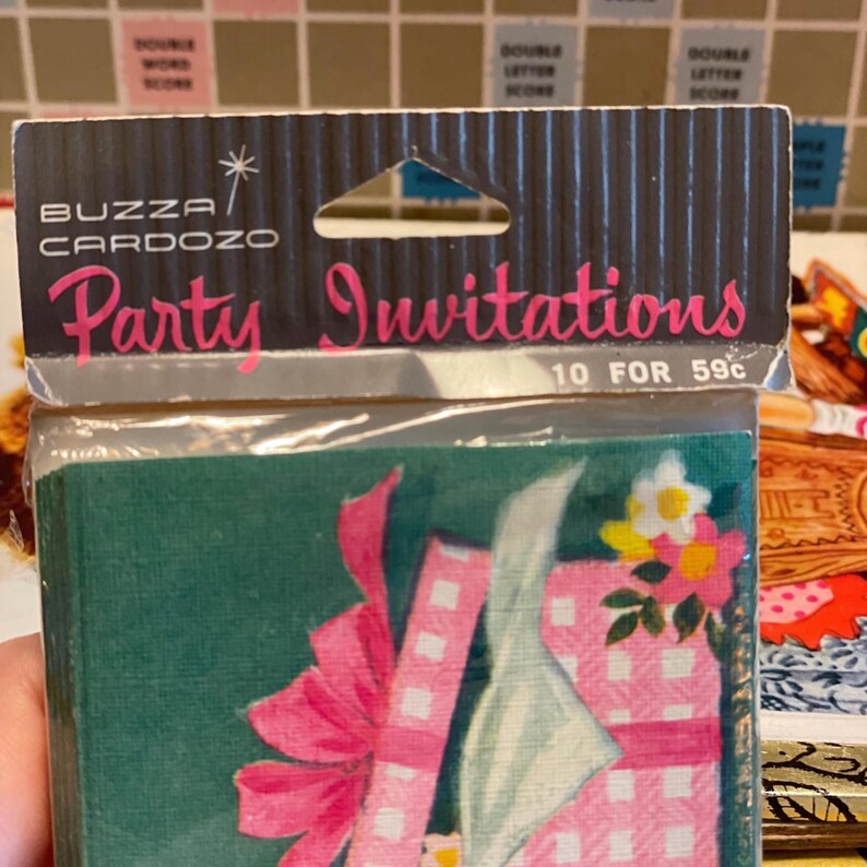 May include: Vintage party invitations in a sealed package. The package features the text "Party Invitations" in pink script, with a floral illustration and a pink bow. The brand name "BUZZA CARDOZO" is also visible.