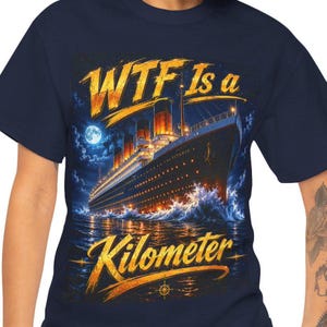 Può includere: T-shirt blu navy con grafica della nave Titanic di notte, con la scritta "WTF Is a Kilometer" in oro. Il design include una luna piena, onde e una bussola nautica.