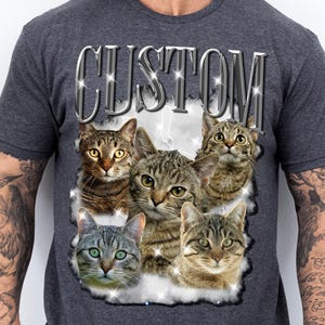 May include: Dark gray t-shirt featuring a graphic of five cats with various tabby patterns. The word "CUSTOM" is printed above the cats in a silver, sparkling font. The cats are set against a cloudy background.