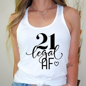 May include: White tank top with black text that says "21 legal AF" with a small heart symbol.
