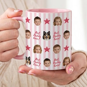 May include: A pink and white striped mug with a pink handle and interior. The mug is decorated with photos of children, a dog, and the text "Best Daddy Ever!" along with pink stars. The mug is being held.