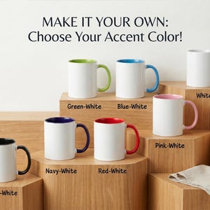 May include: A collection of white ceramic mugs with various accent colors, including green, blue, pink, red, navy, and black. The mugs are displayed on wooden blocks, with text above that reads "MAKE IT YOUR OWN: Choose Your Accent Color!"