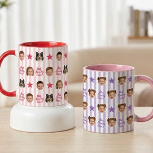 May include: Two ceramic mugs with personalized designs. One mug has a red handle and interior, featuring faces, stars, and the text "Best Daddy Ever" on a pink striped background. The other mug has a pink handle and interior, with faces, stars, and the text "Best Daddy Ever" on a purple striped background.