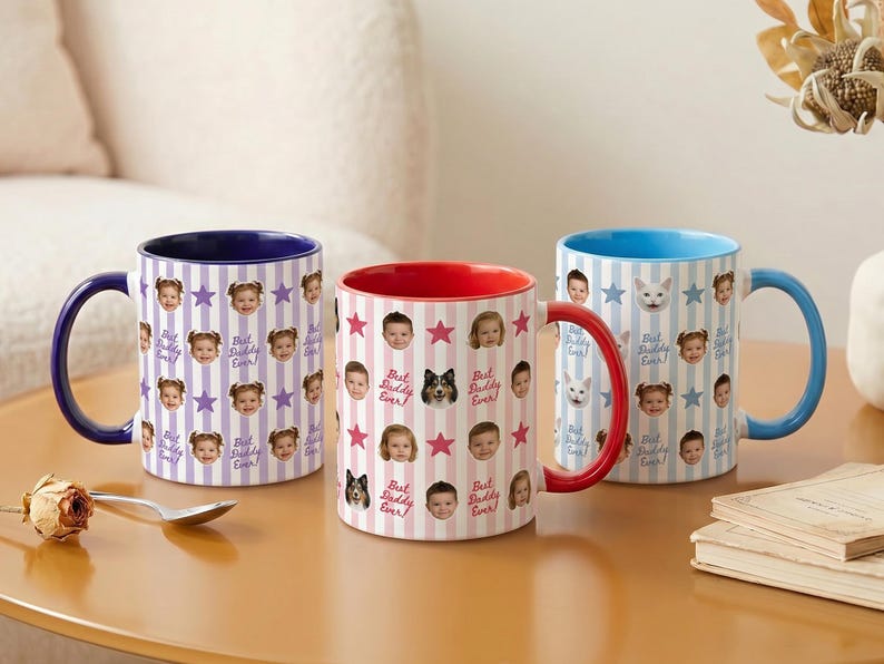 May include: Three ceramic mugs with colorful handles and interiors. Each mug features a repeating pattern of faces, stars, and the text "Best Daddy Ever!". The mugs have blue, red, and blue handles and interiors.