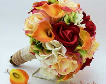 Puede incluir: Un ramo de novia con lirios calla naranja, rosas rojas, hortensias blancas y follaje verde. El ramo está atado con arpillera y encaje.
