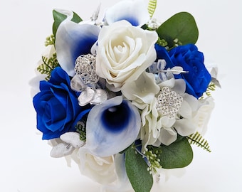 May include: A bridal bouquet with white roses, blue calla lilies, and blue roses accented with silver foliage and rhinestones.