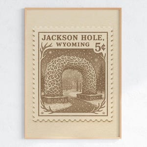 May include: Framed print featuring a vintage-style postage stamp design. The stamp depicts an archway made of intertwined branches, with the text "Jackson Hole, Wyoming" and a "5&cent;" value. The artwork is in sepia tones, suggesting a nostalgic aesthetic.