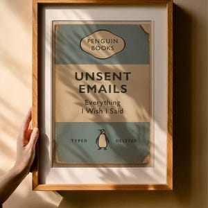 May include: A framed print with the text "UNSENT EMAILS Everything I Wish I Said" from Penguin Books. The print features a vintage design with a penguin illustration and is encased in a wooden frame.