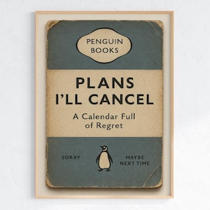 May include: Framed print featuring a vintage-style design with the text "PLANS I'LL CANCEL" and "A Calendar Full of Regret." The print includes a Penguin Books logo and a small penguin illustration. The color palette includes blue, beige, and black.