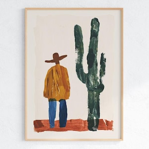 May include: Abstract art print depicting a figure in a hat and poncho beside a large green cactus. The figure wears blue trousers. The artwork is framed in a natural wood frame.