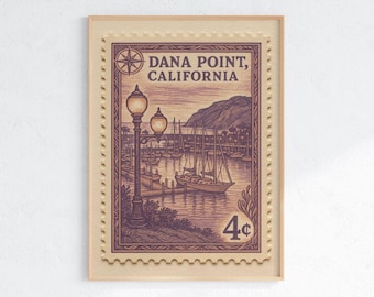 May include: Framed vintage-style print of a Dana Point, California stamp. The illustration features a harbor scene with sailboats, a mountain, and street lamps. The stamp is in shades of purple and brown, with a 4¢ value.